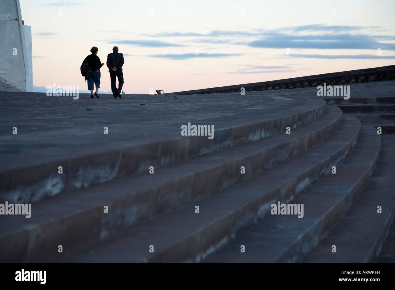 einzelne einsame Frau mit Wachmann zu Fuß entfernt von Schritten auf mit Mann in der Ferne in Santa Cruz Teneriffa Kanarische Inseln Stockfoto