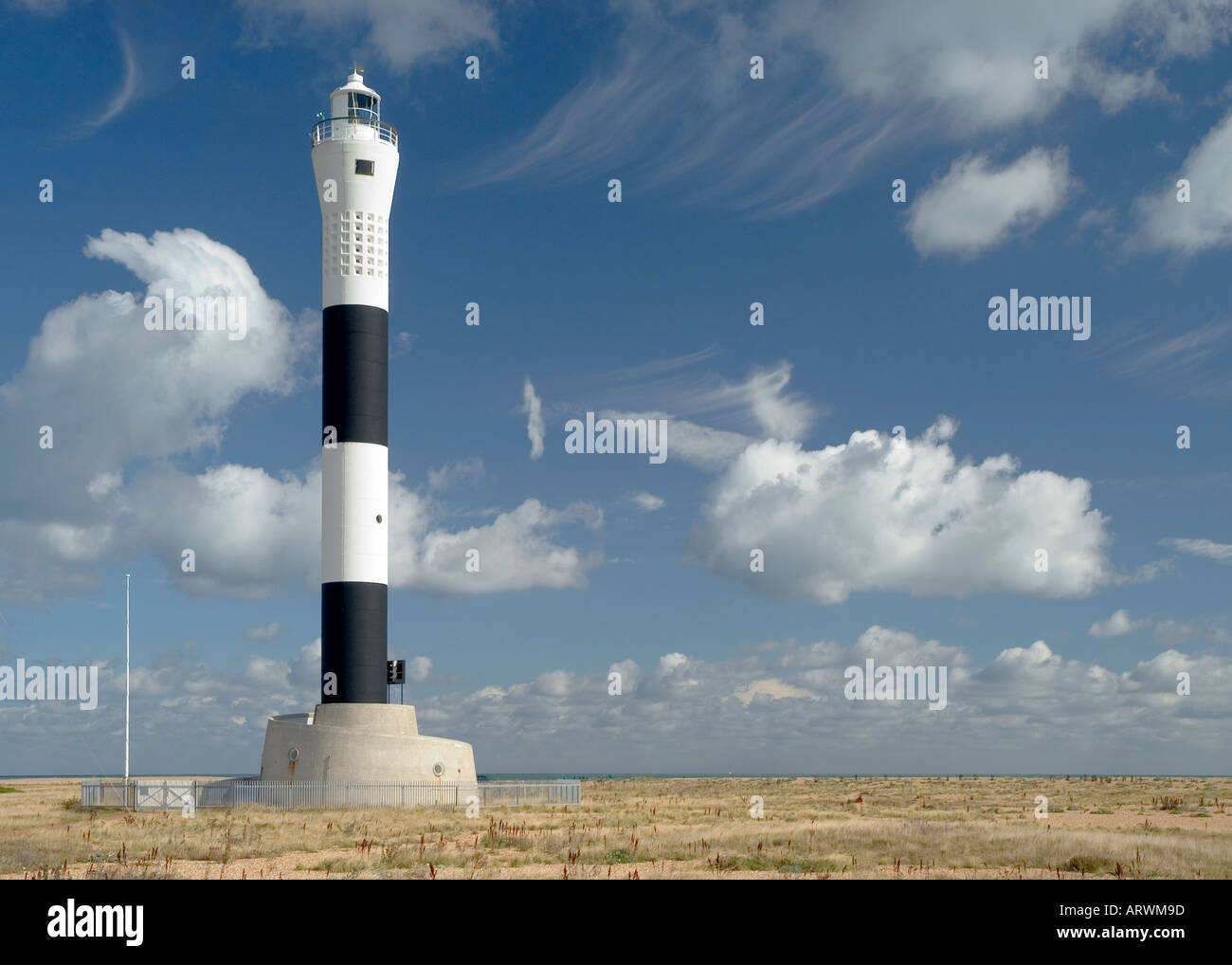 Ein schwarz-weiß stiped Leuchtturm am Strand von Dungeness, Kent. Stockfoto