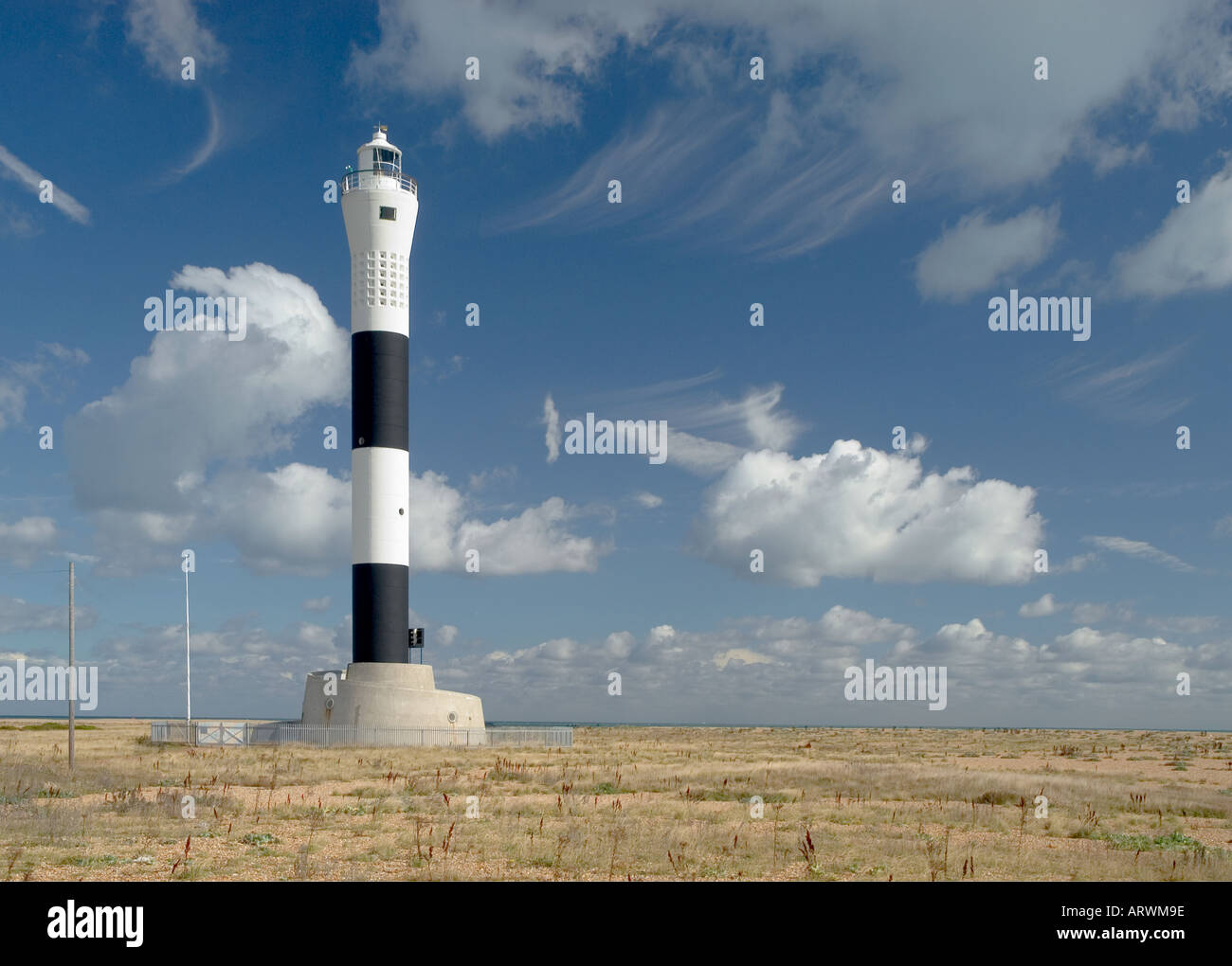 Ein schwarz-weiß stiped Leuchtturm am Strand von Dungeness, Kent. Stockfoto