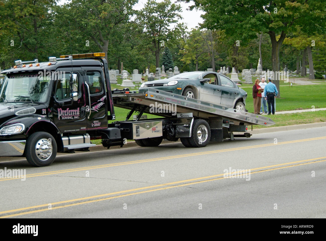 Autounfall verletzt eine Frau während Polizei zum Wrack zu besuchen, telefonisch einen Abschleppwagen um das Auto zu entfernen Stockfoto