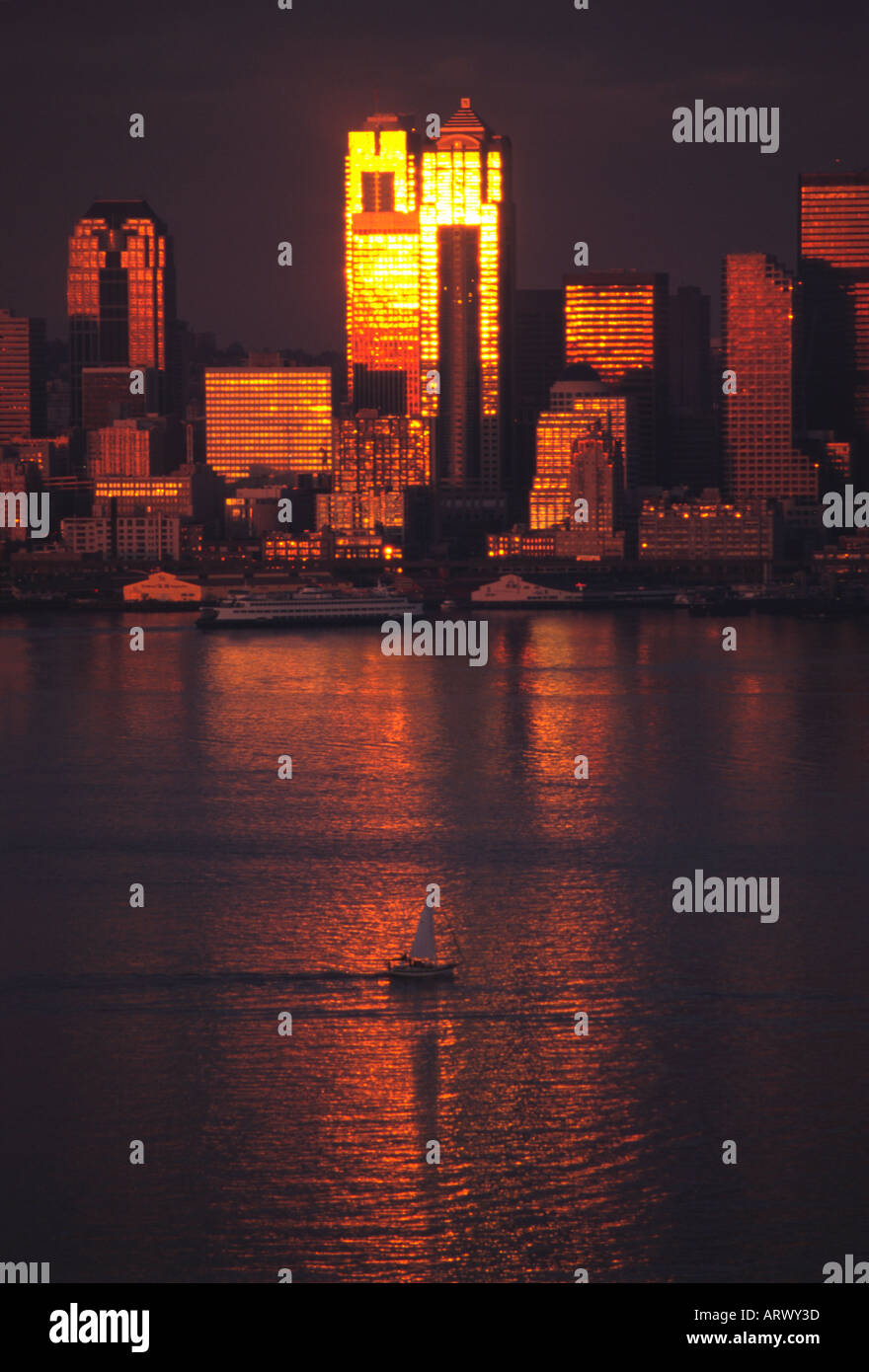 Blick über Elliot Bay von der Sonne von Gebäuden in der Innenstadt von Seattle Washington mit Segelboot im Wasser reflektiert Stockfoto