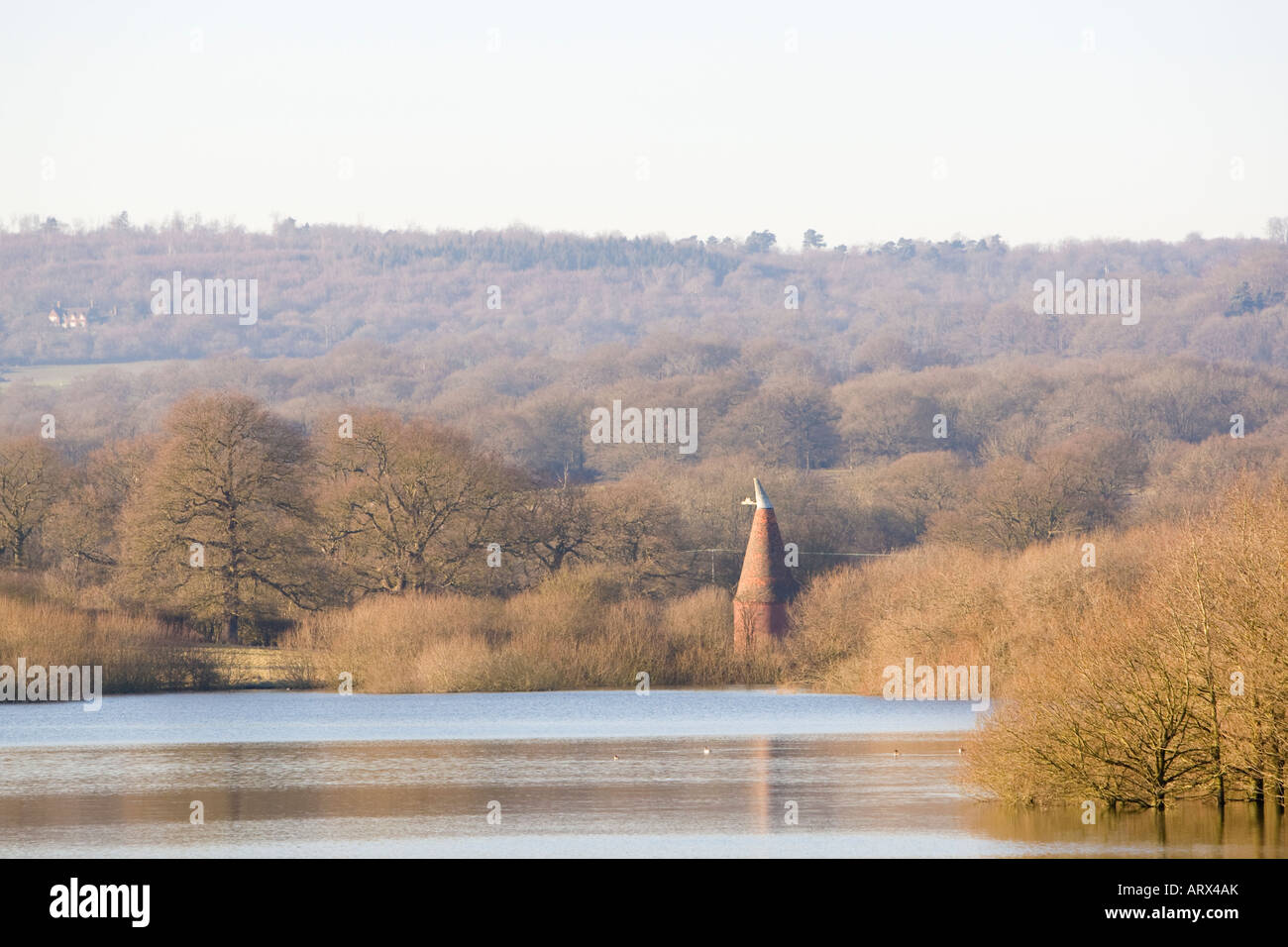 Blick über Ast Buche Reservoir mit Oast House in den Bäumen in der Nähe von Sevenoaks Kent UK winter Stockfoto