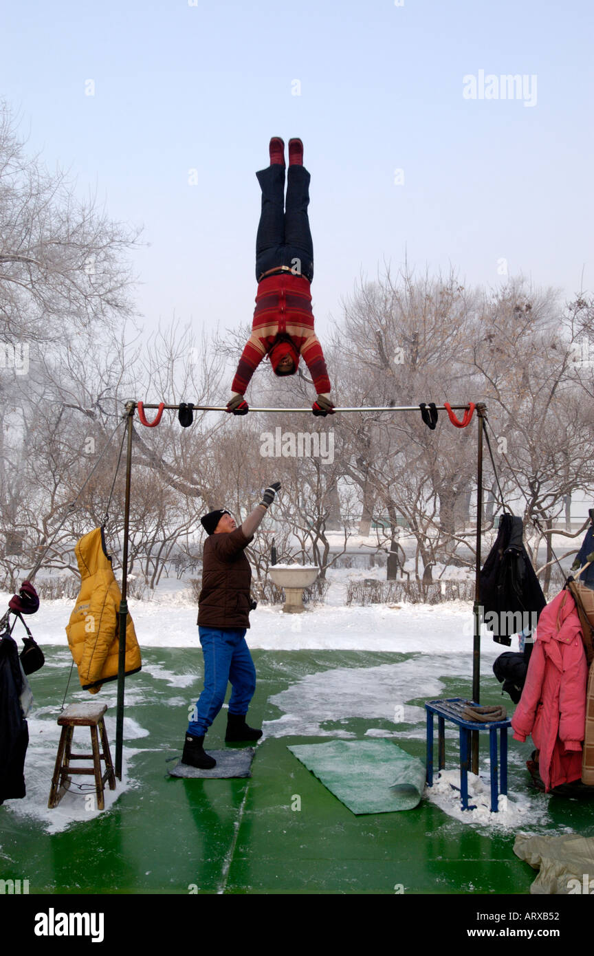 Eine chinesische Frau mittleren Alters am frühen Morgen Turnen in Stalin Park Harbin in China Winter 2005 Stockfoto