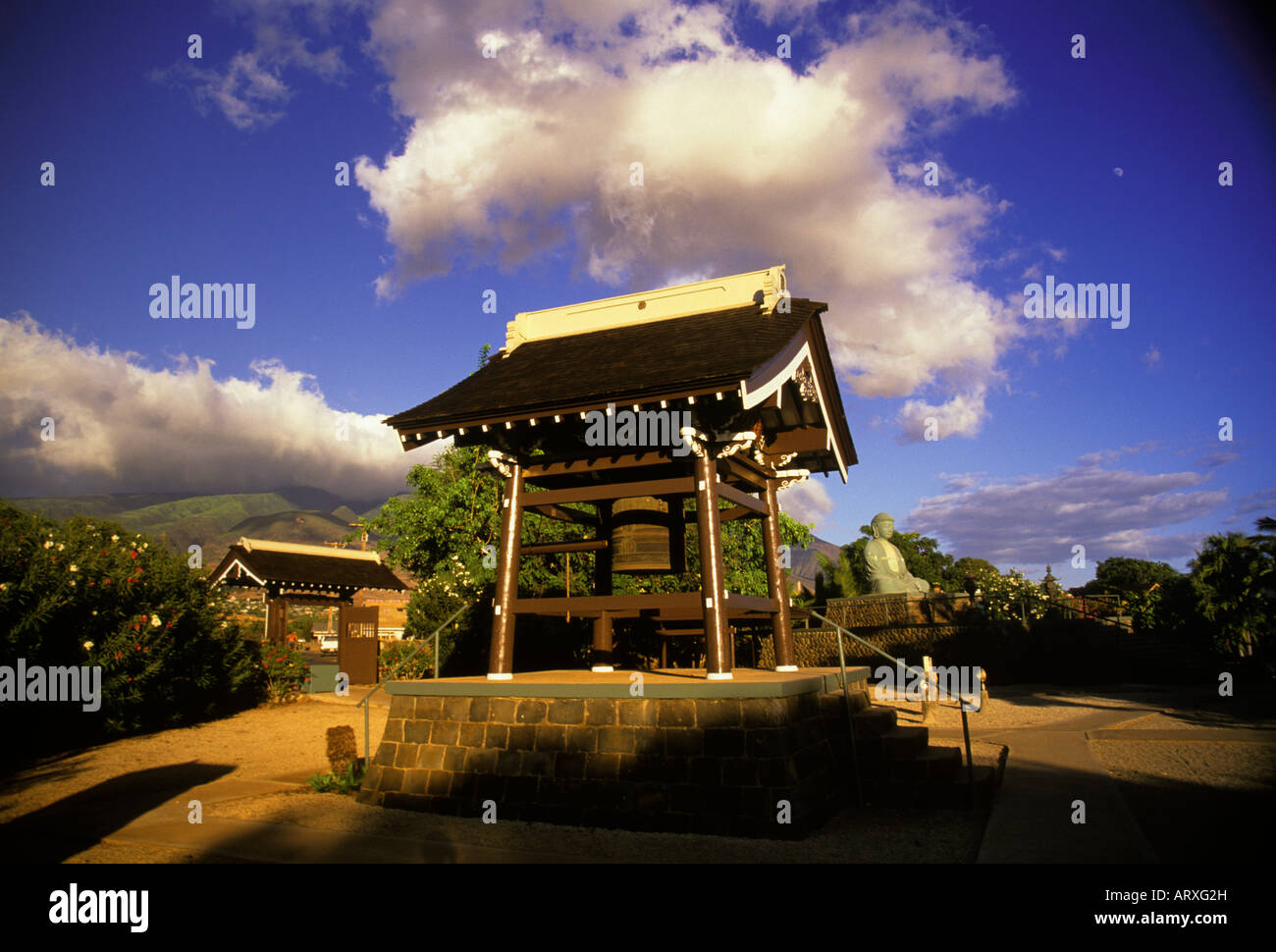 Viel Glück Bell, Buddah und Eintrag Tor im Jodo Mission, Lahaina, Maui. Mond und West Maui Mountains im Hintergrund Stockfoto