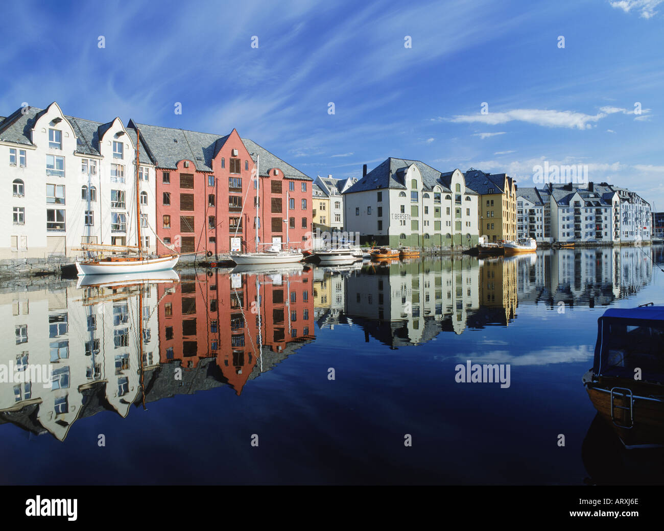 Häuser und Boote am Kanal bei Sonnenaufgang in Ålesund, Norwegen Stockfoto