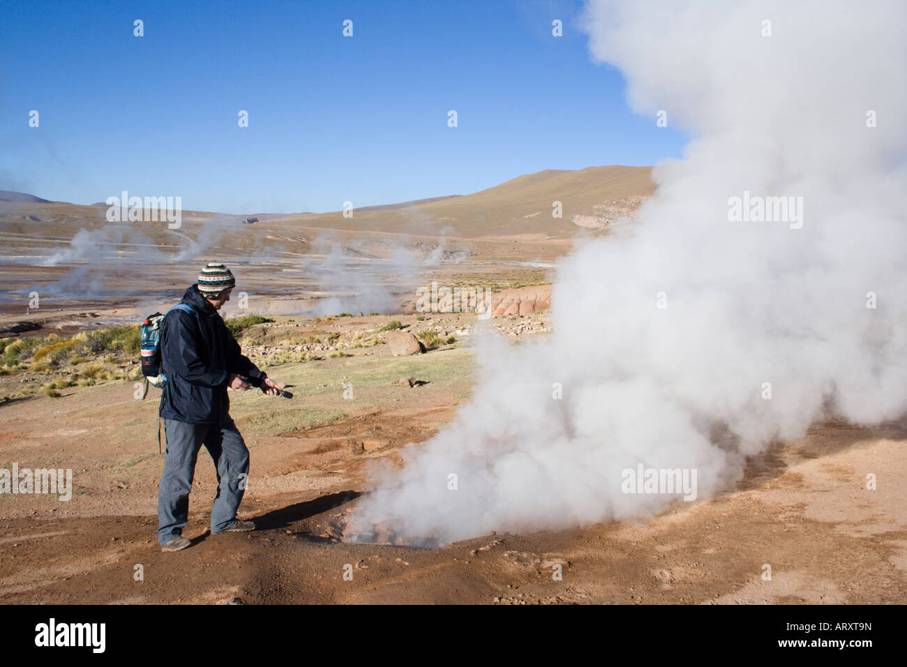 Ein Journalist der Aufnahme den blubbernden Sound von El Tatio Geysir, San Pedro de Atacama, Chile, Südamerika Stockfoto