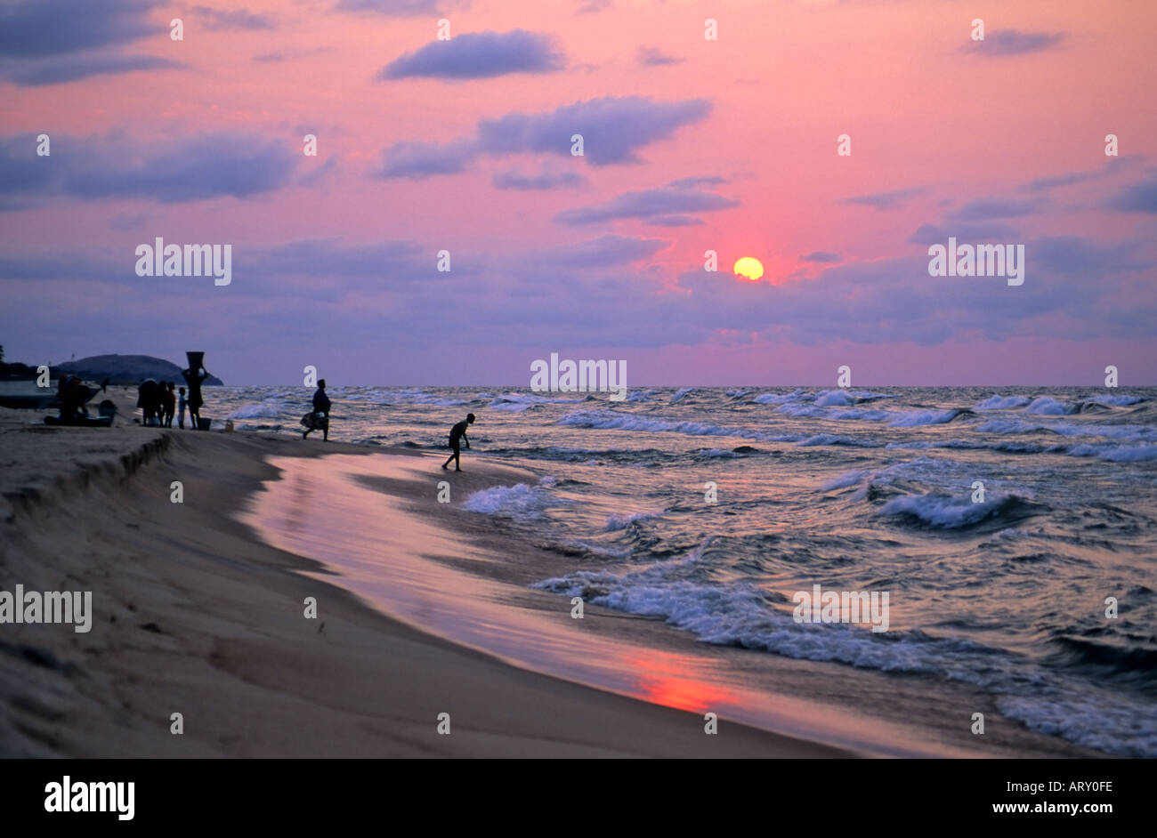 Frauen sammeln Wasser aus Malawi-See in der Dämmerung, in der Nähe von Kande, Malawi Stockfoto