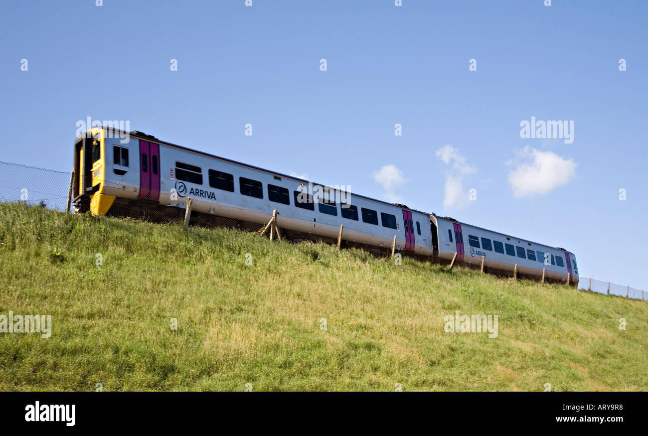 Elektrisch betriebene Zug Beschleunigung entlang der Böschung Colwyn Bay Wales UK Stockfoto