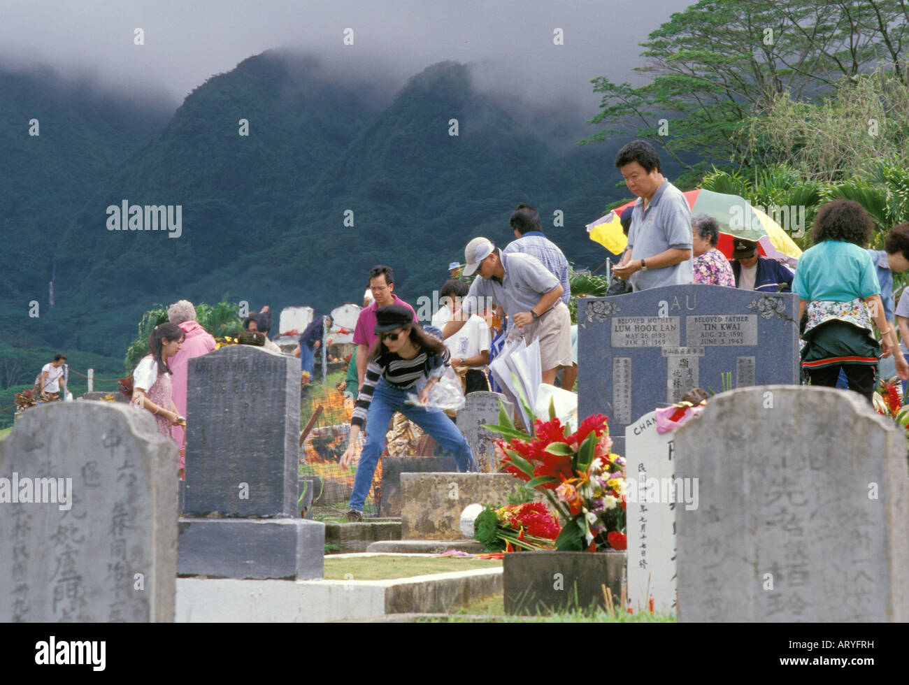 Familien um Grabsteine für Ching Ming, einer jährlichen chinesischen Zeremonie zu Ehren der Vorfahren, Manoa chinesischen Friedhof versammelt, Stockfoto