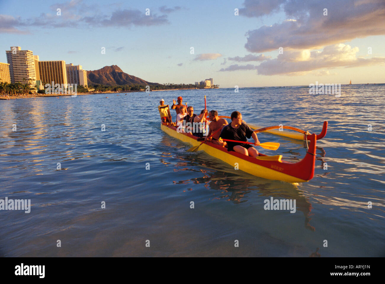 Touristen, die paddeln ein Auslegerkanu aus Waikiki mit Diamond Head im Hintergrund Stockfoto