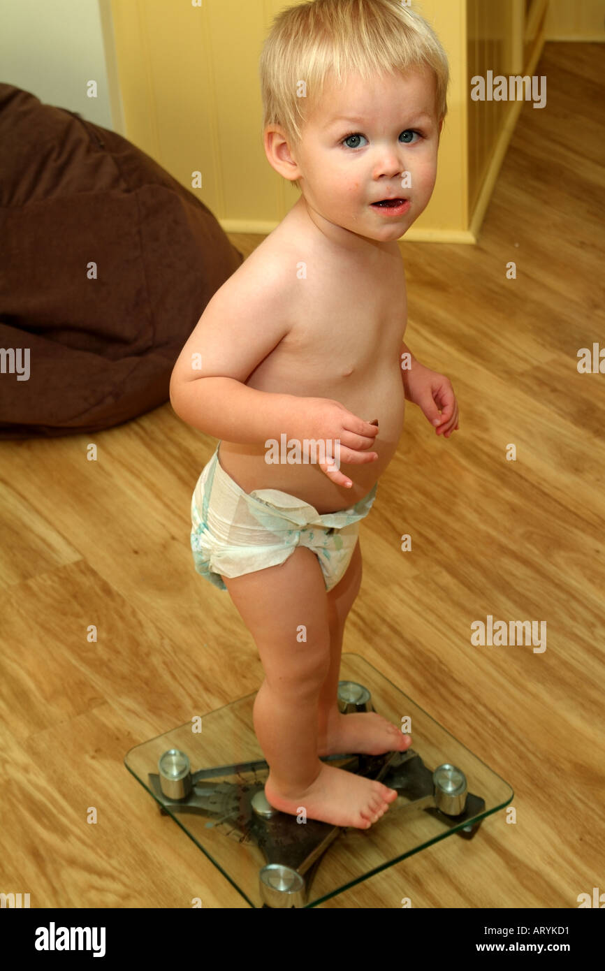 Kleinen Jungen Spaß wiegen sich auf Badezimmer Waagen Stockfoto