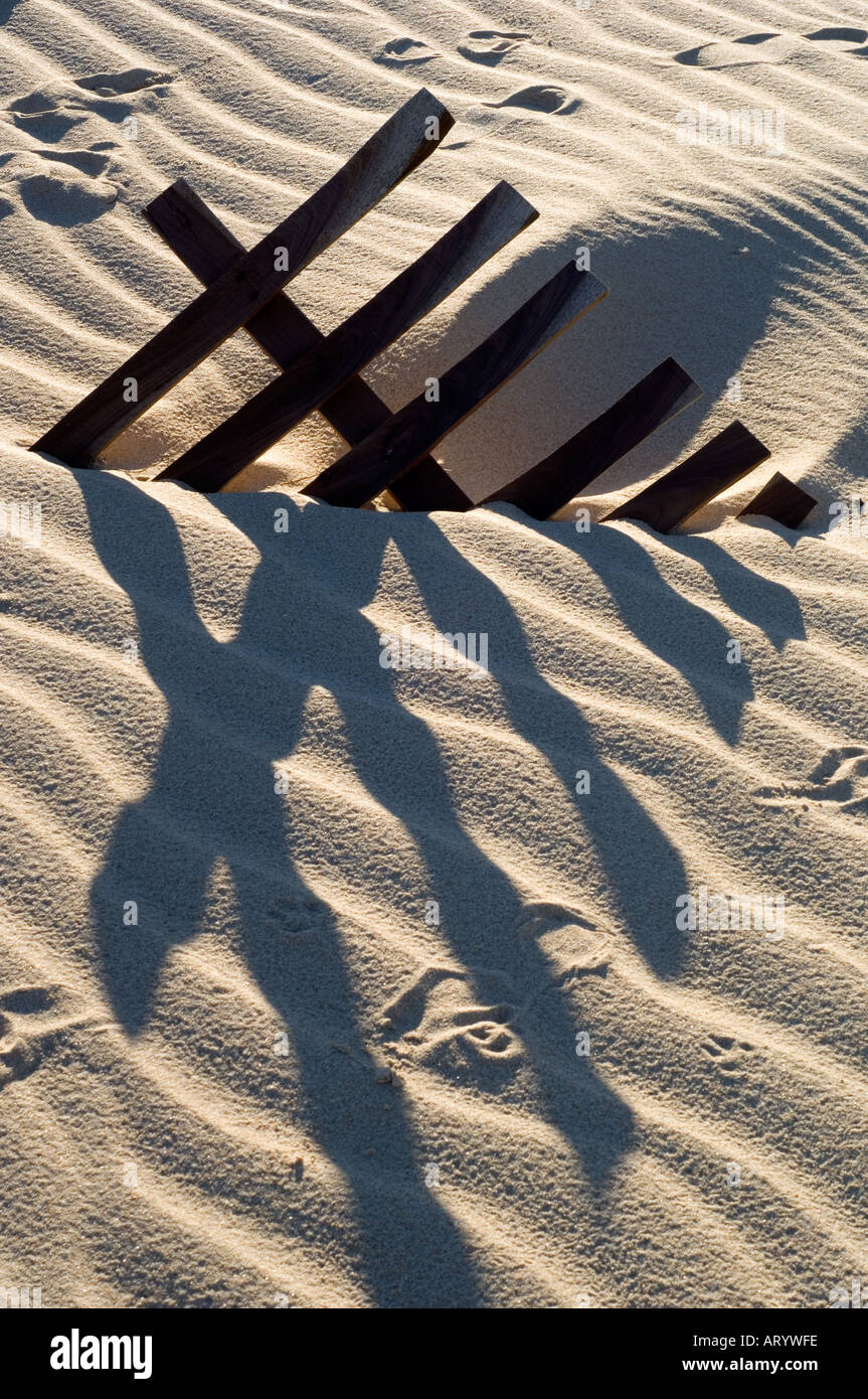 Konzeptbild eines Zauns teilweise vergraben im Sand Tarifa Cadiz Spanien Stockfoto