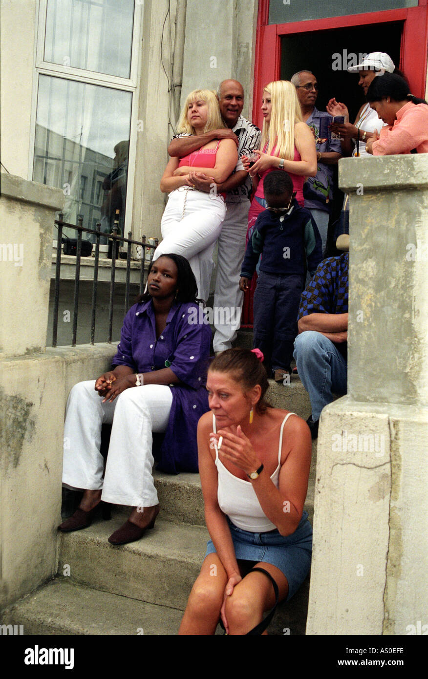 Gemischtrassigen Gruppe Geselligkeit auf ihrer Haustür Schritt während der Notting Hill Carnival in London. Stockfoto