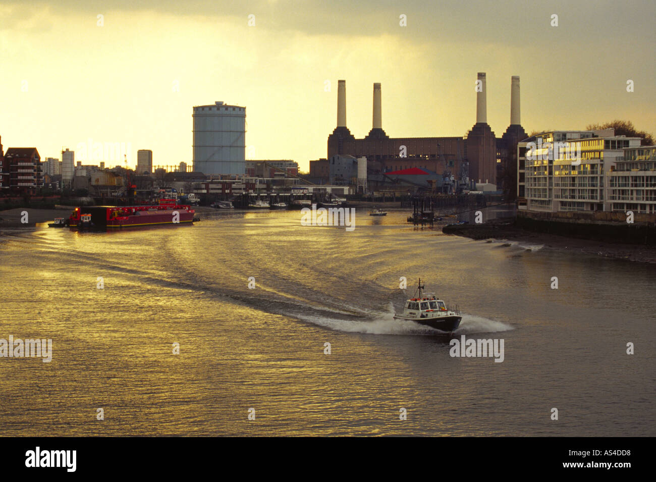 Polizeiboot hinunter Themse mit Battersea Power Station im Hintergrund. Stockfoto