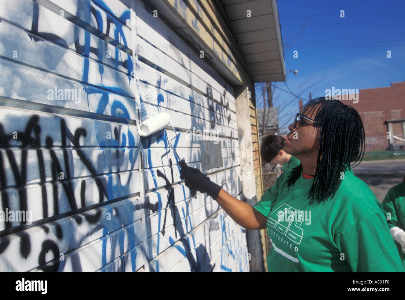 Freiwillige Farben über Graffiti-Bande auf Garage im Südwesten Detroit Stockfoto