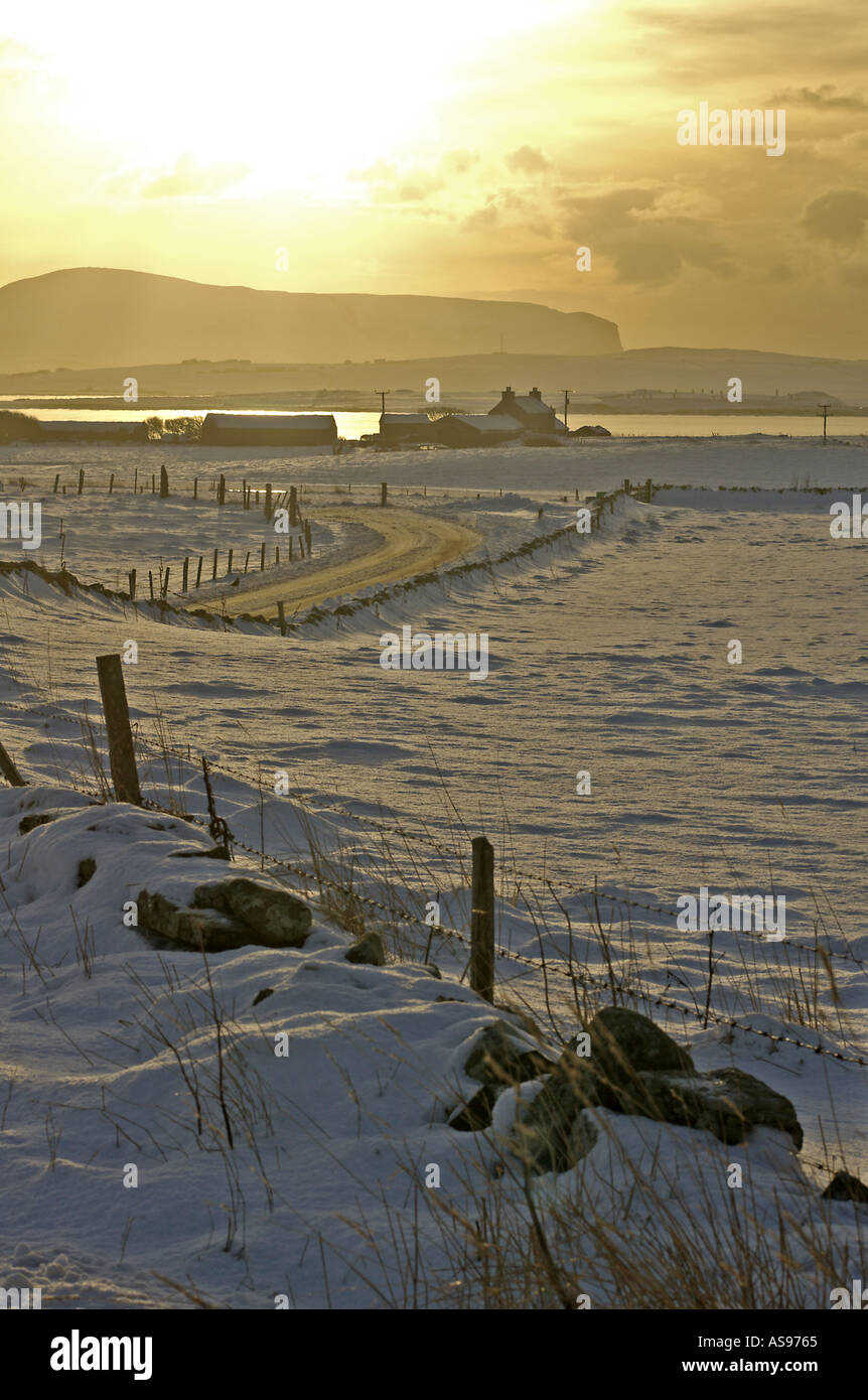 dh Loch Harray HARRAY ORKNEY Bronze Abenddämmerung Schneefelder und Haus Loch Harray und Stenness Hoy Hügel Stockfoto