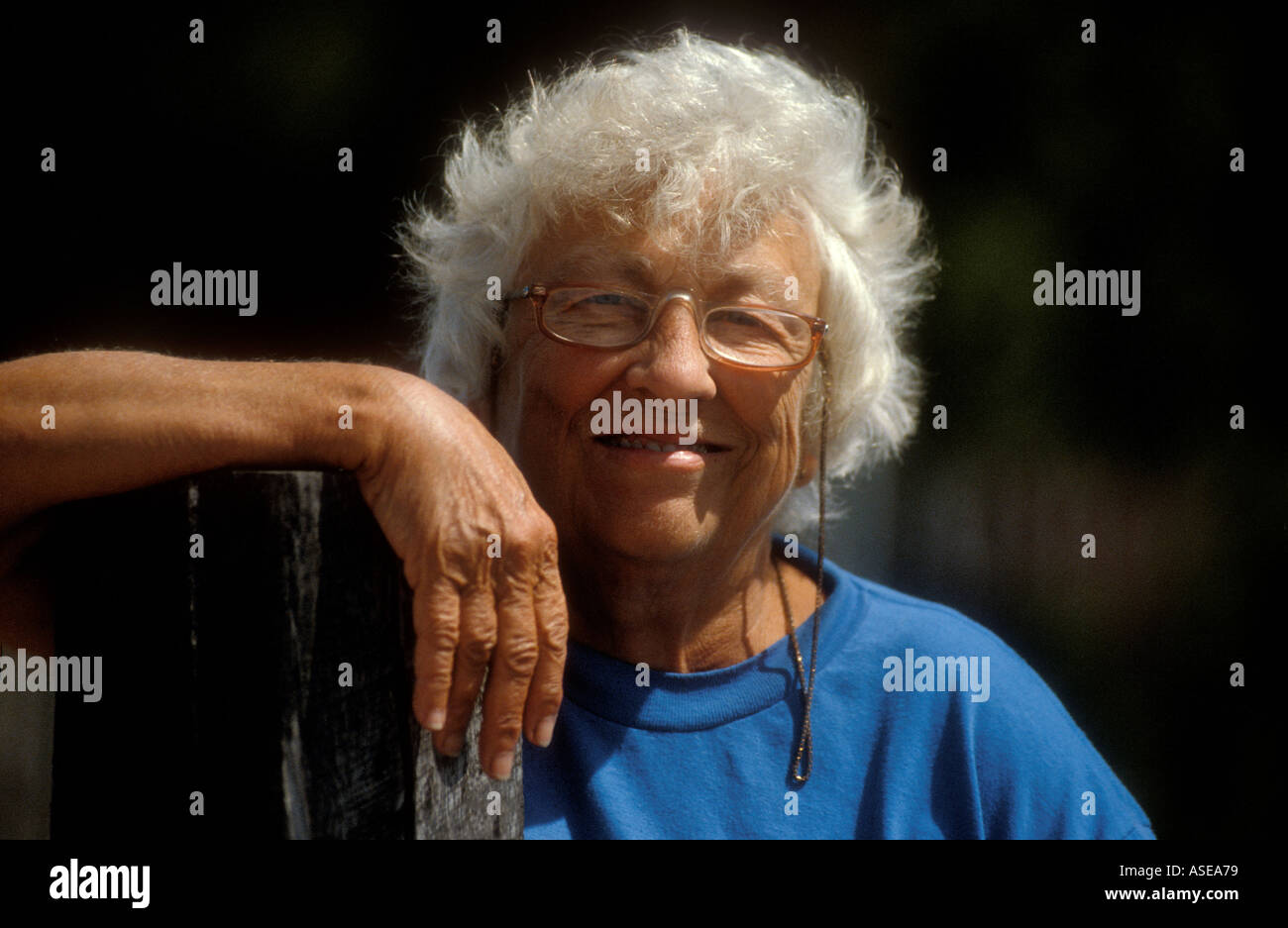 Älteren senior Frau mit weißem Haar und Brille lächelt und schaut glücklich Stockfoto