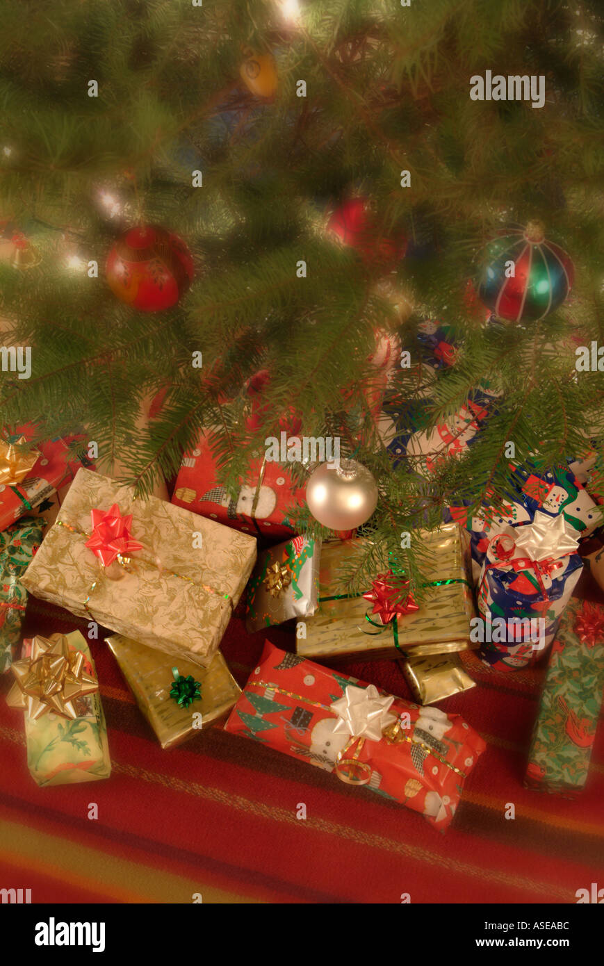 verpackte Weihnachtsgeschenke und Geschenke unter ein geschmückter Weihnachtsbaum Stockfoto