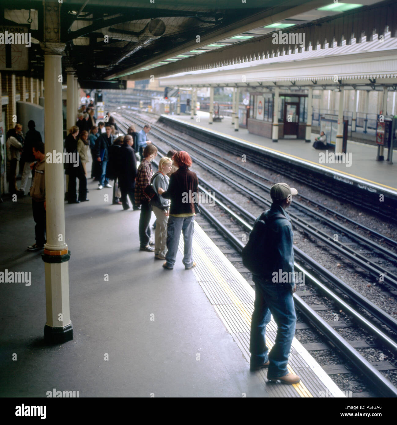 Passagiere warten auf einen Zug auf der Plattform in der High Street Kensington Station in West London UK KATHY DEWITT Stockfoto