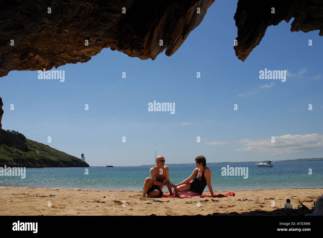 Ehepaar Sonnenbaden am Molunan Strand entlang der South West Coast Path aus St Anthony Head zurück zum Ort Ferry gegenüber St Mawes Stockfoto