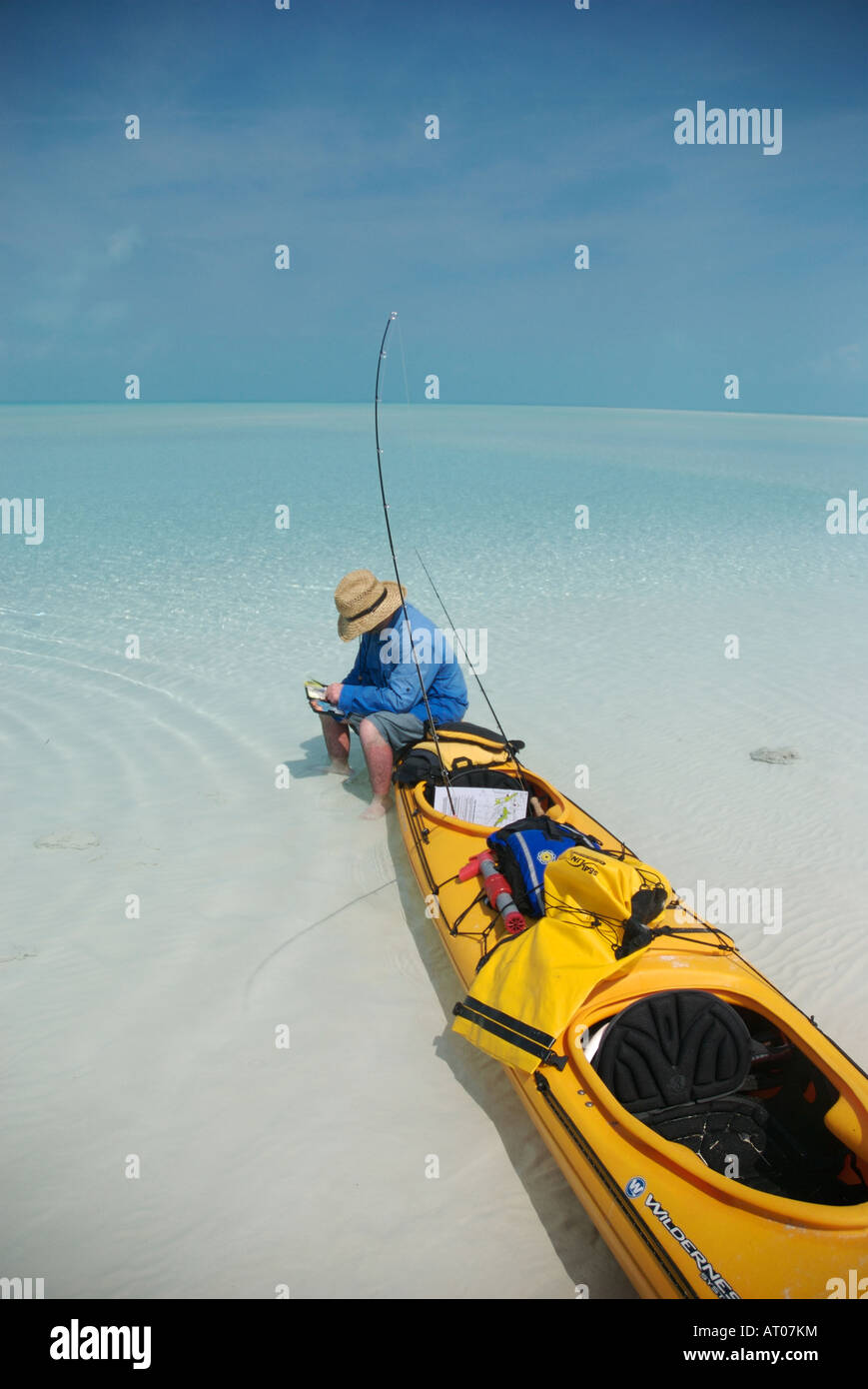 ein Fliegenfischer sitzt auf seinem Kajak Auswahl eine Fliege für Bonefishing auf den Bahamas Exuma Inseln Stockfoto