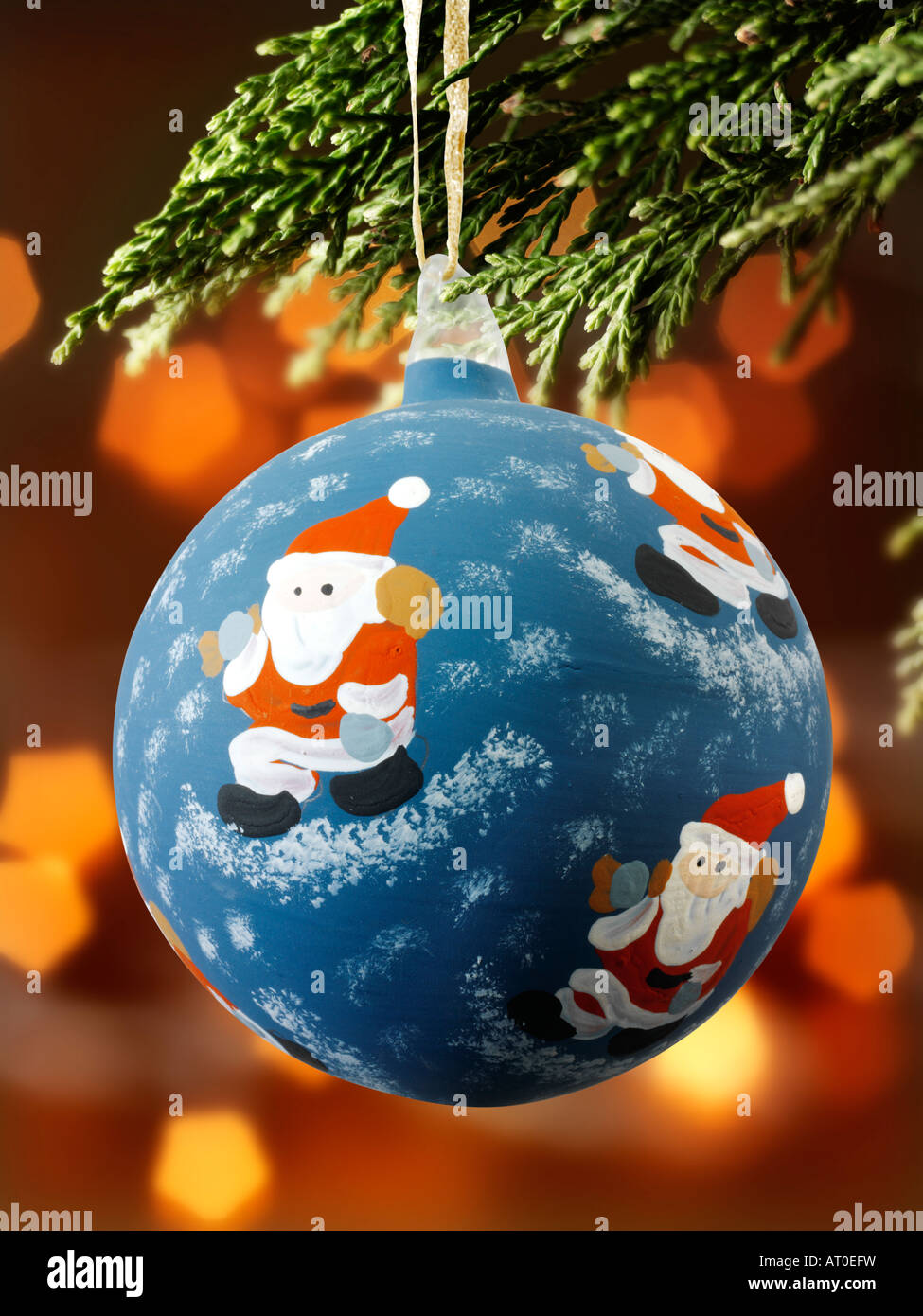 Traditionelle festlich geschmückte weihnachtsbaumkugel, die an Weihnachten hängt Baum mit Lichtern dahinter Stockfoto