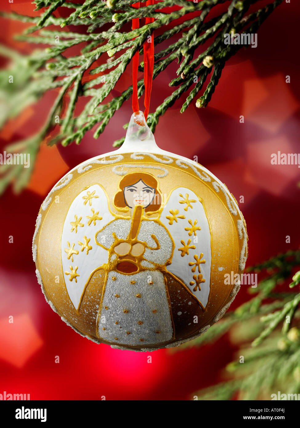 Traditionelle festlich geschmückte Weihnachtsengel-Kugel, die an Weihnachten hängt Baum mit Lichtern dahinter Stockfoto