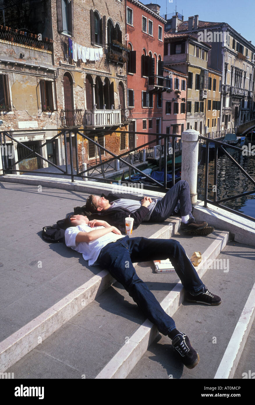 Zwei erschöpfte Touristen ruhen auf einer Brücke in Cannaregio Bezirk von Venedig. Stockfoto