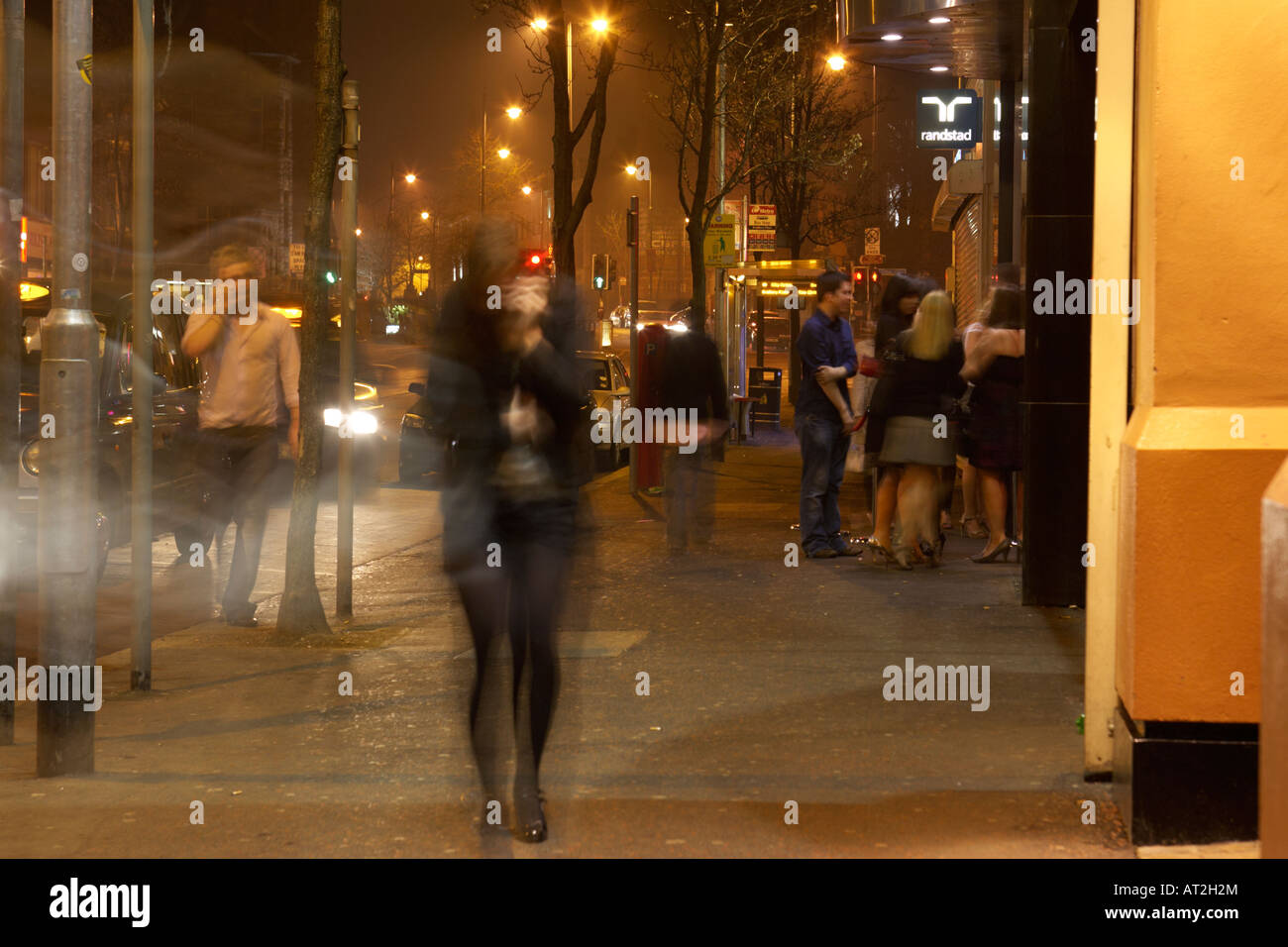 Menschen Nachtklubber, die nachts im Winter an Kneipen und Clubs auf dem bradbury Place belfast vorbeilaufen, in der UK-Bewegungsunschärfe und Bewegung Stockfoto