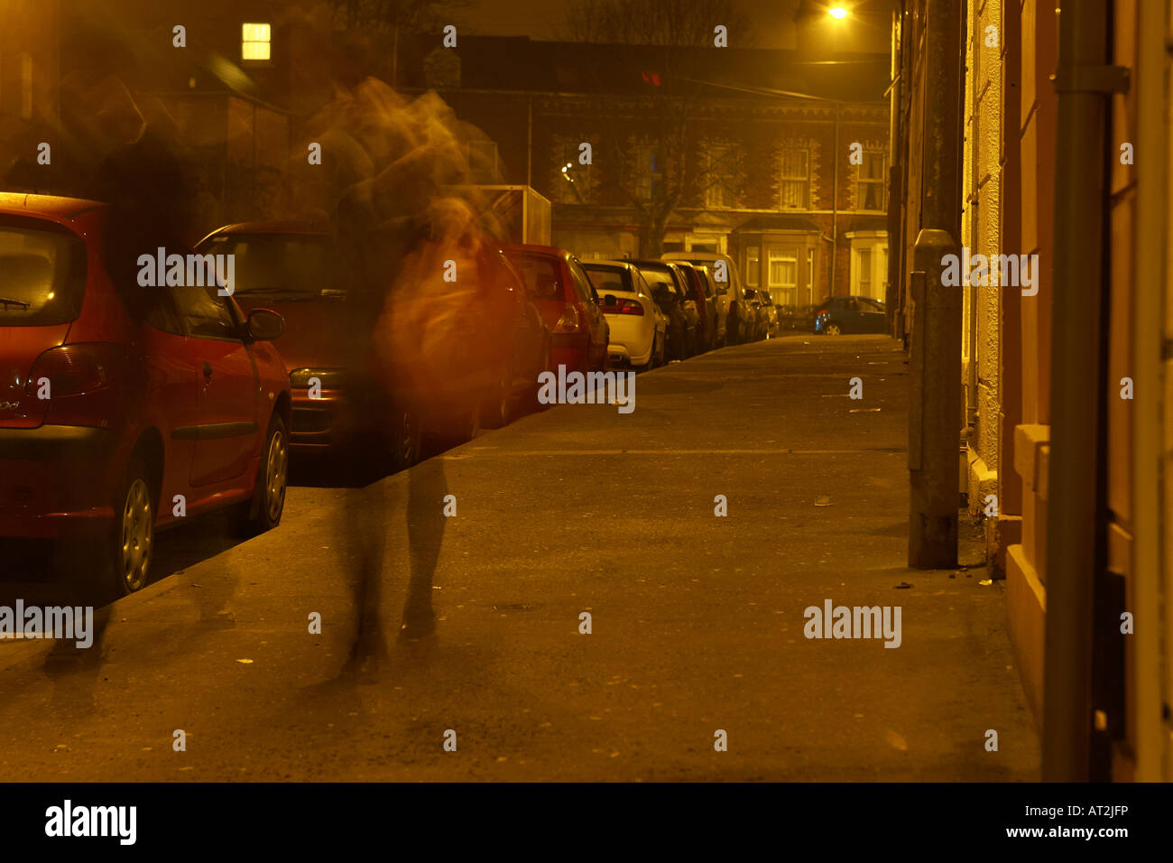 Paare, die unter der Straßenlaterne auf schmalen dunklen Nacht Straße in Belfast Stockfoto