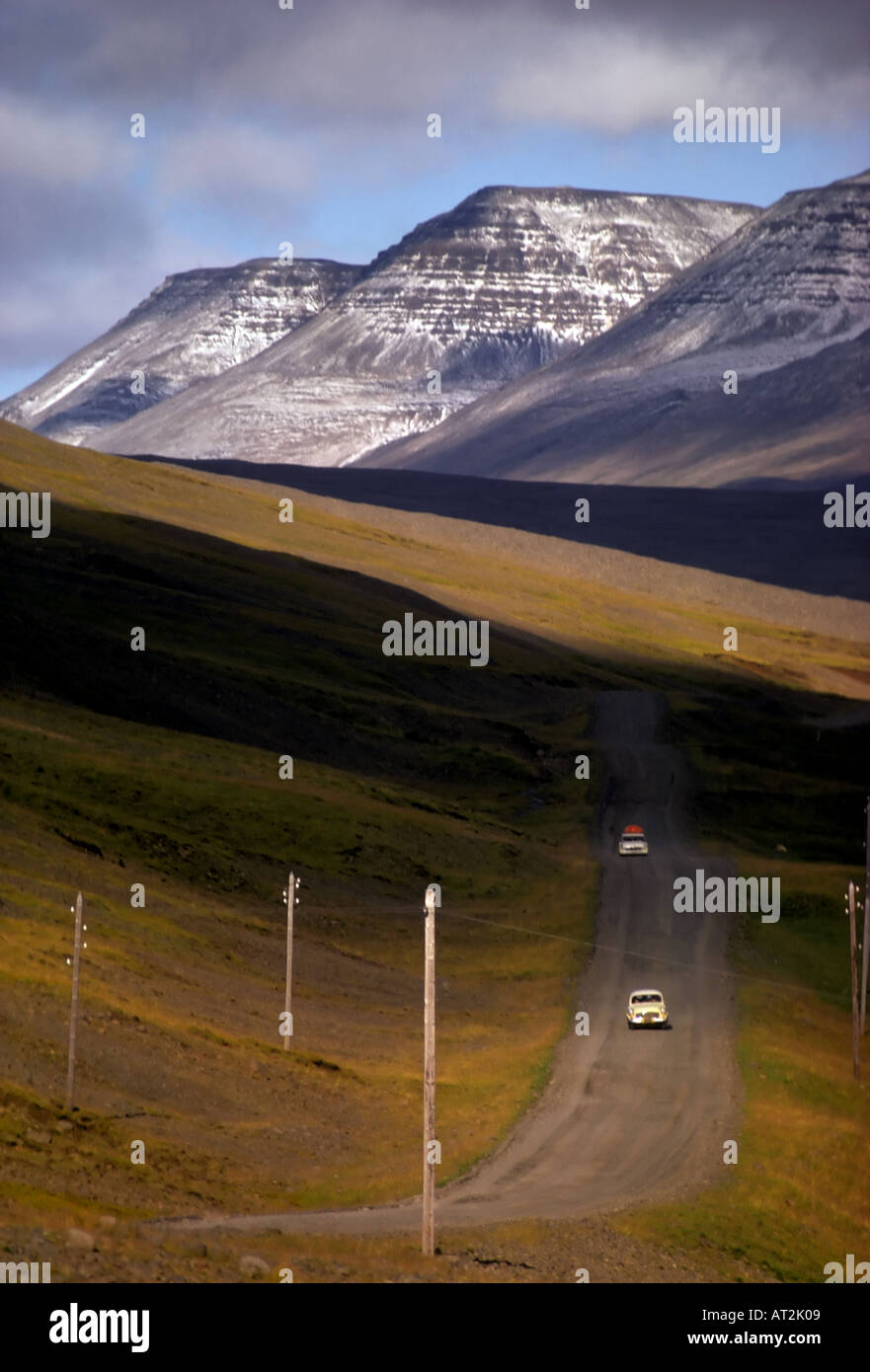 Eine unbefestigte Straße in Island s Vesterland Bezirk mit Schnee bedeckt Hallmundarhraun Berge im Hintergrund Stockfoto