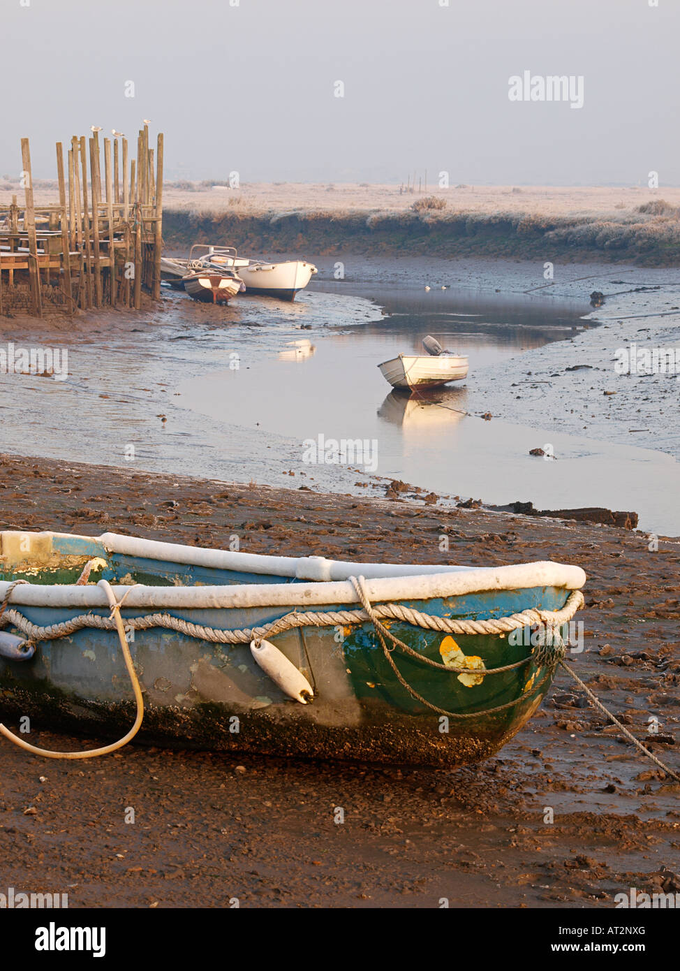 MORSTON CREEK BEI EBBE MIT BOOT AUF GRUND GELAUFEN, FROSTIGEN WINTER MORGEN, NORTH NORFOLK ENGLAND UK Stockfoto