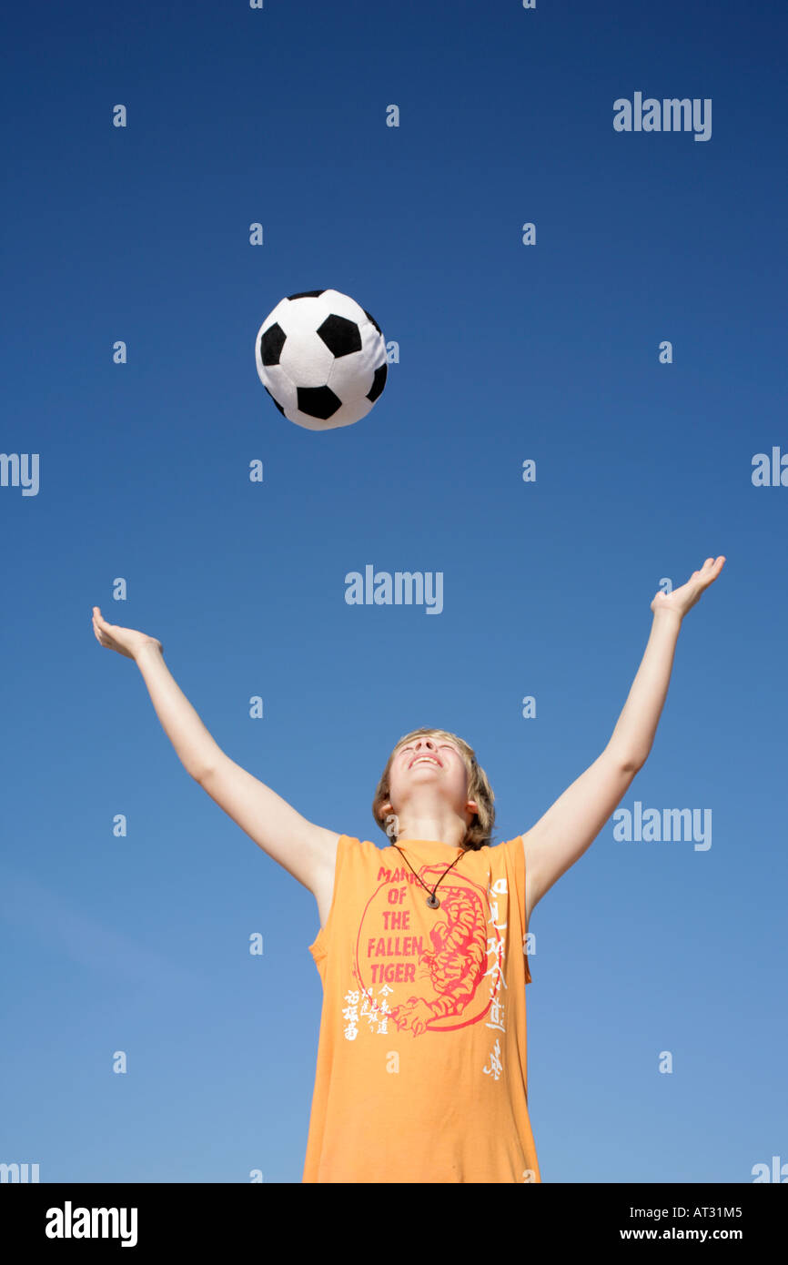 ein kleiner Junge werfen einen Ball in der Luft Stockfoto