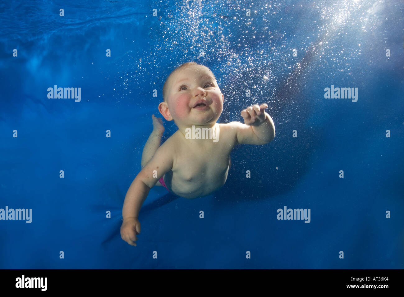 Baby unter Wasser im Pool auf blauem Hintergrund Stockfoto