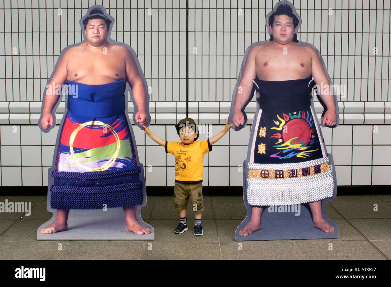 Ein Junge stellt neben Leben Größe Fotos von Top Sumo-Ringer in Tokyo Japan 2004 Stockfoto
