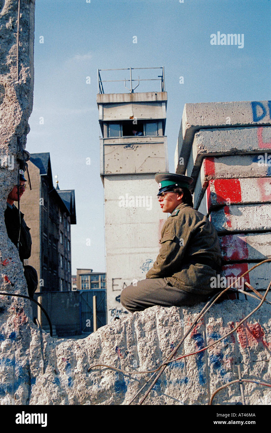 Der Fall der Berliner Mauer 1989. Eine Wache sitzt auf den gebrochenen Resten der Berliner Mauer Stockfoto
