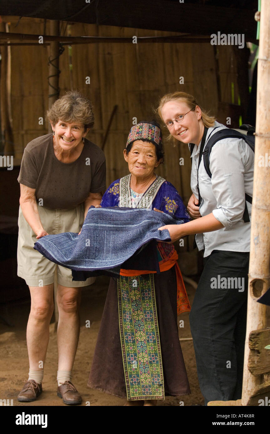 Zwei Touristen kaufen Batiken Hanf Stoff von einer Hmong-Frau im Dorf Baan Pha Nok Kok Doi Inthanon Nationalpark Thailand Stockfoto