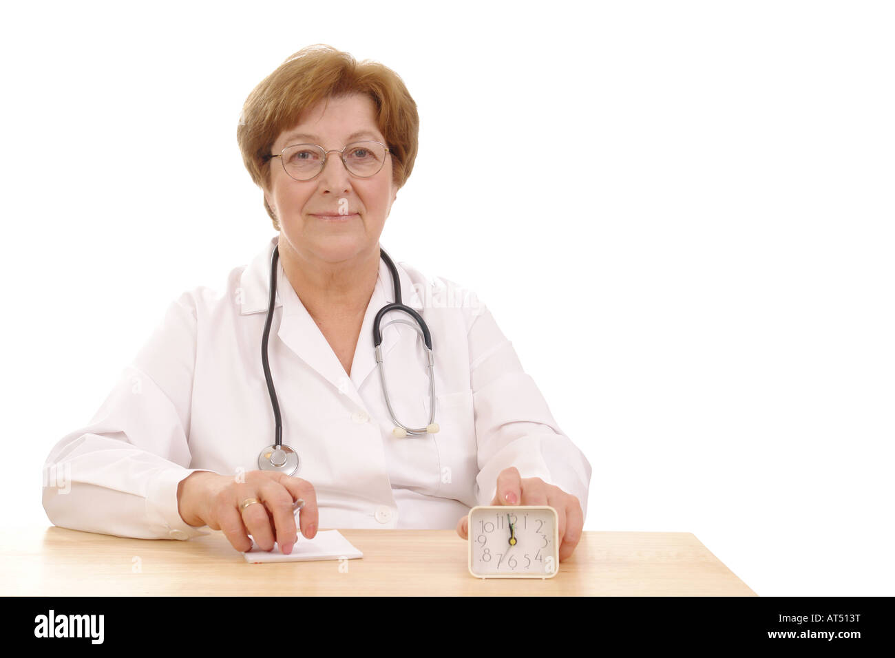 Leitender Arzt der Familie mit Stethoskop sitzt hinter einem Schreibtisch mit den Fingern anziehen Wecker Stockfoto