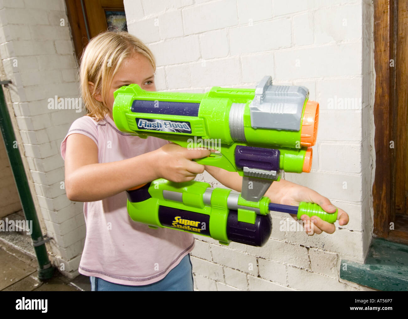 Junge Mädchen spielen mit enormen Pumpe Action Wasserpistole auf der Suche  nach ihrem nächsten Ziel in einem Straßenkampf, UK Stockfotografie - Alamy