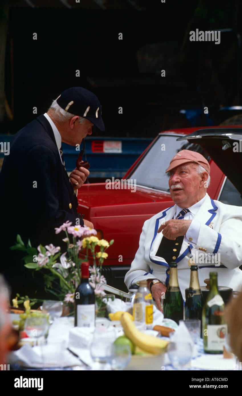 Zwei alte Männer tragen Rudern club Kappen und Blazer im Chat auf dem Parkplatz bei der Henley Royal Regatta, Oxfordshire UK Stockfoto