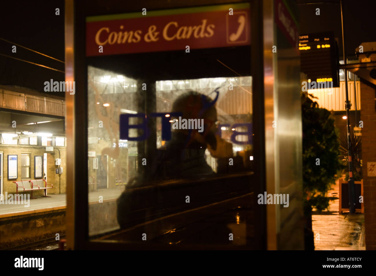 Mann in Box machen Telefonanruf auf Bahnsteig spät in die Nacht Stockfoto