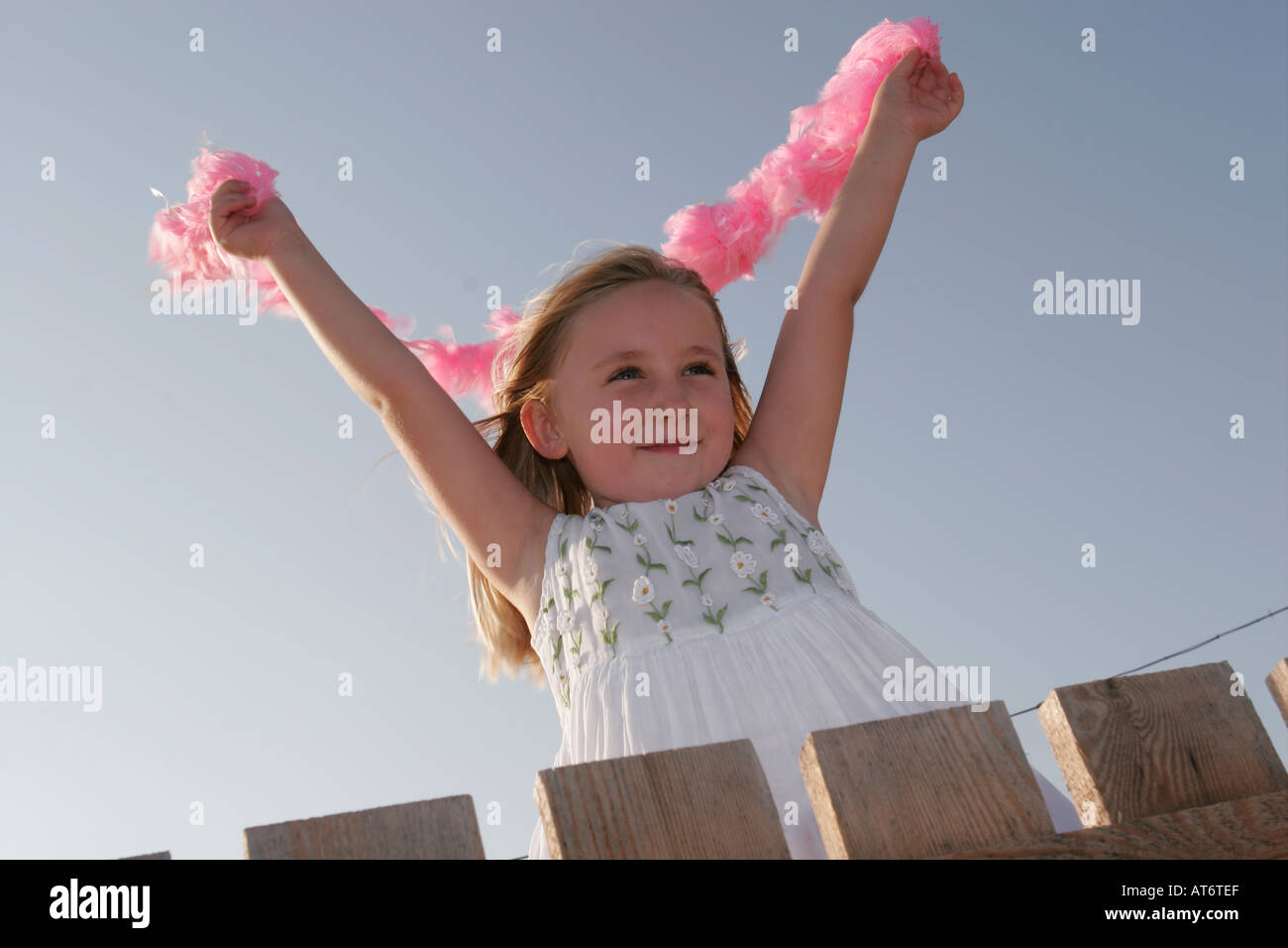 Blonde Mädchen Holding Federboa im wind Stockfoto