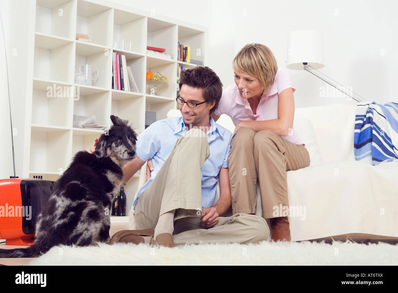 Paar im Wohnzimmer, mit Hund, Porträt Stockfoto