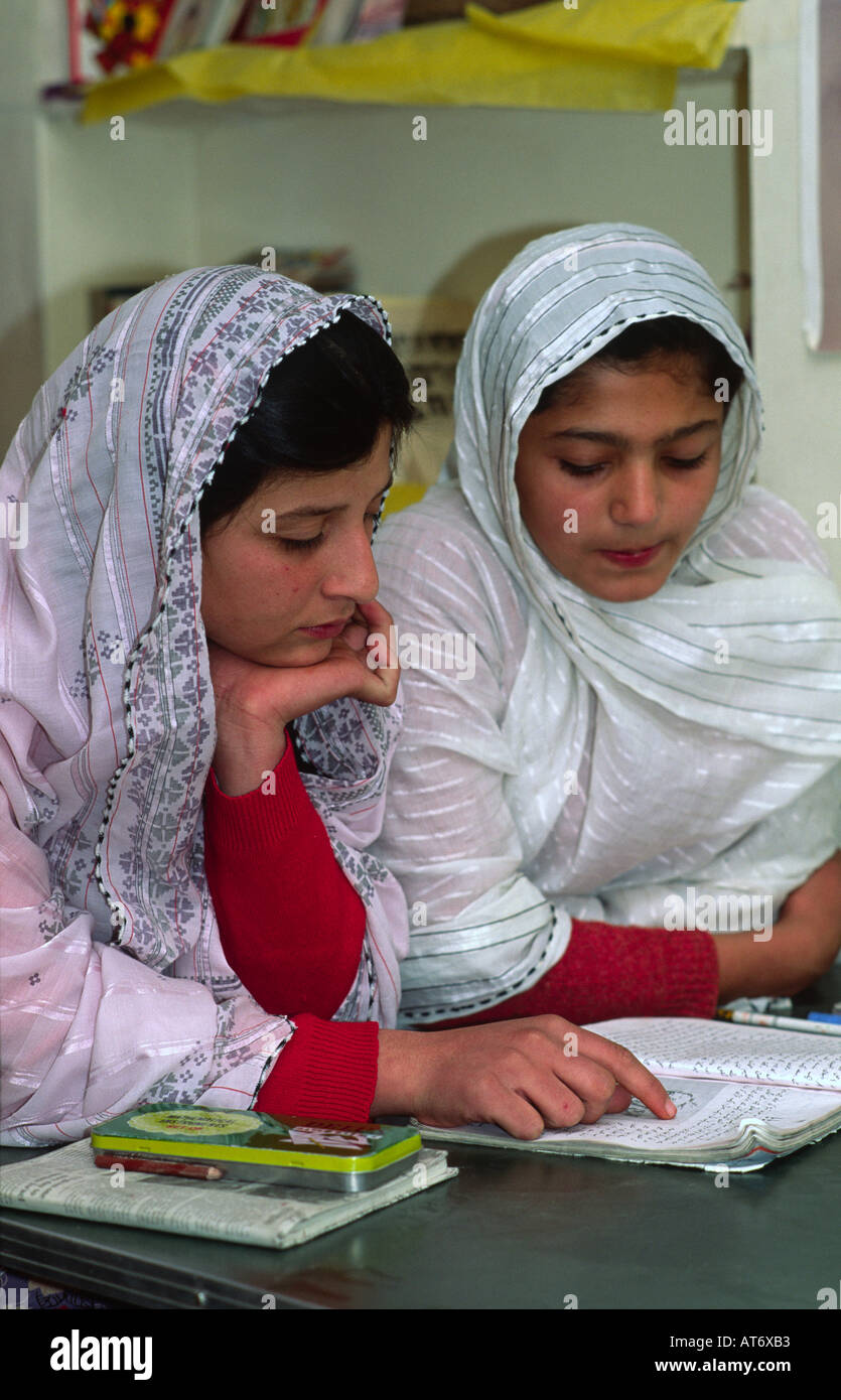 Zwei verschleierte Muslimische Schülerinnen folgenden Text durch einen Mitschüler am britischen Modell Schule lesen. Quetta, Pakistan Stockfoto