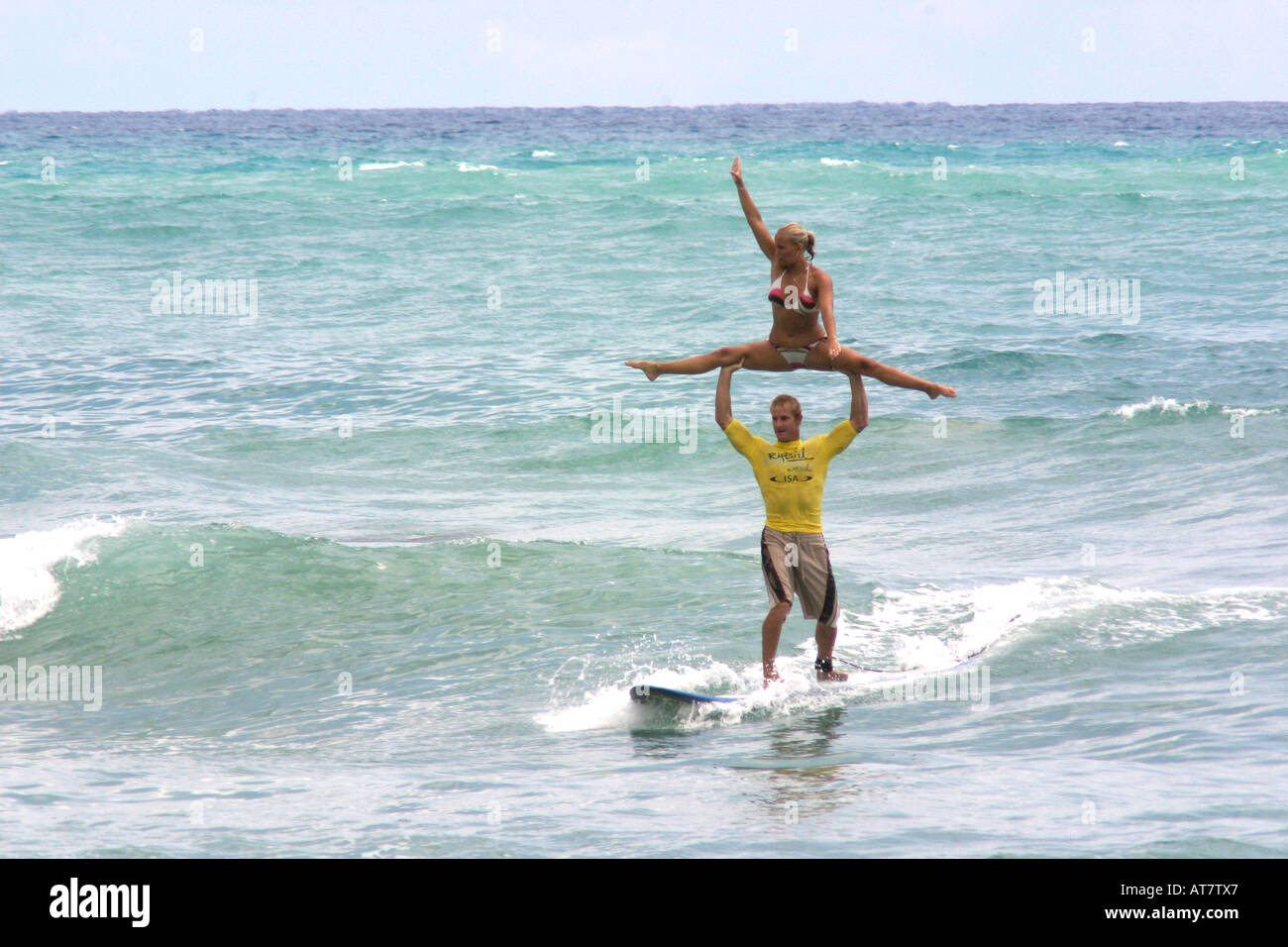 Tandem-Surfen, Mann Betrieb Frau über Kopf Stockfoto