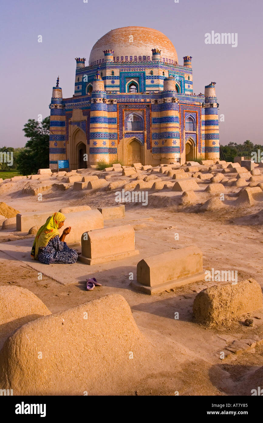Frau auf einem Grab vor der prächtigen Ruinen aus dem XV Jahrhundert Mausoleum von Bibi Jawindi - Uch Sharif Pakistan beten Stockfoto