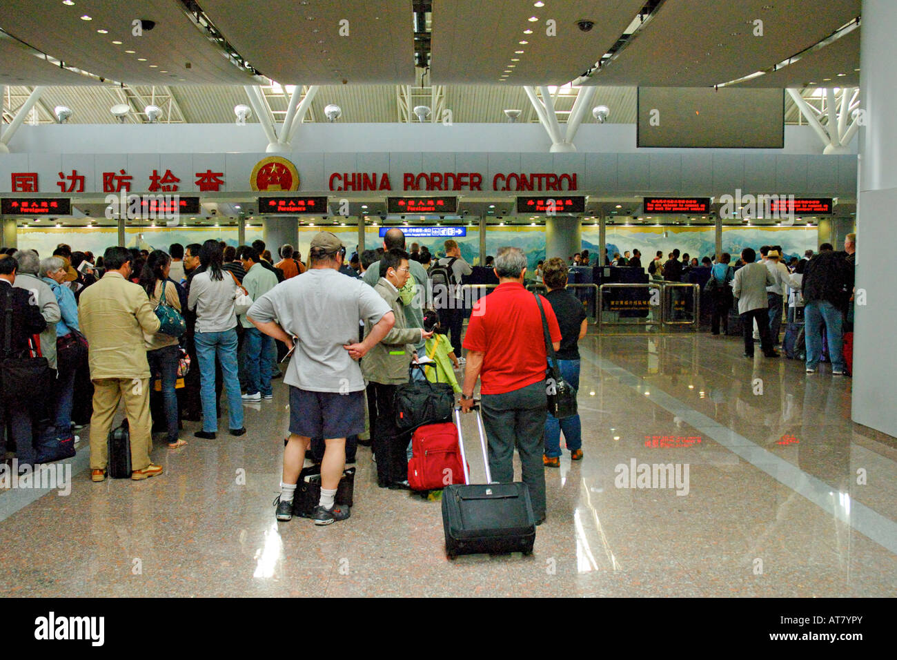 Passagiere am Flughafen Peking form Linien bei der Grenzkontrolle China eingeben Stockfoto