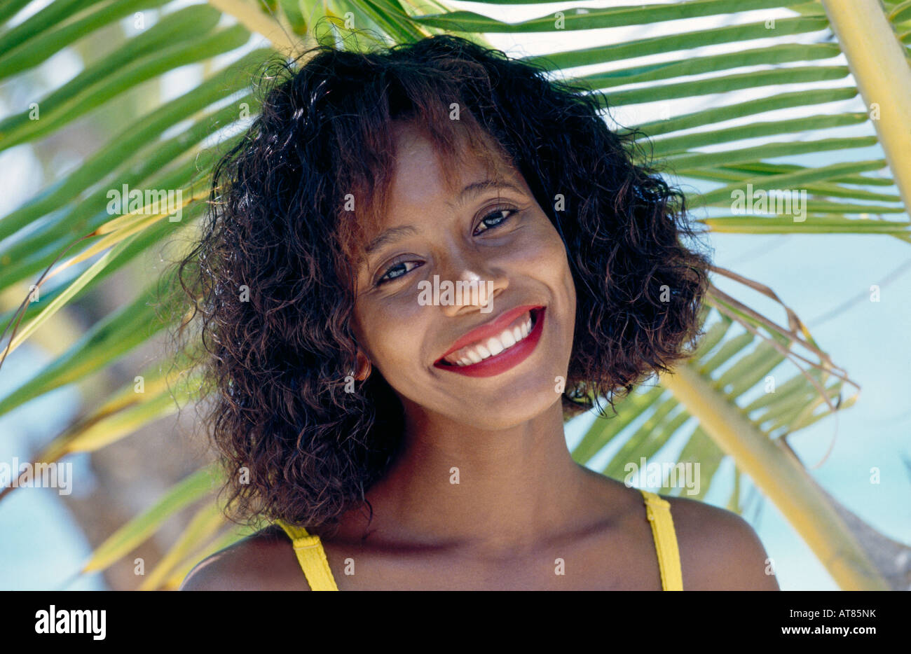 Junge Frau unter Palm Tree Nahaufnahme Stockfoto