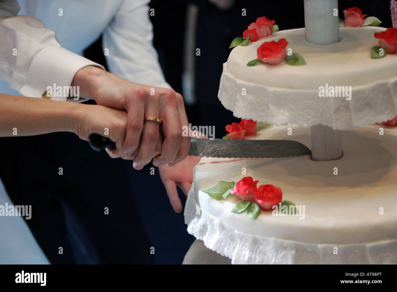 Nahaufnahme von Braut und Bräutigam schneiden Hochzeitstorte. Stockfoto