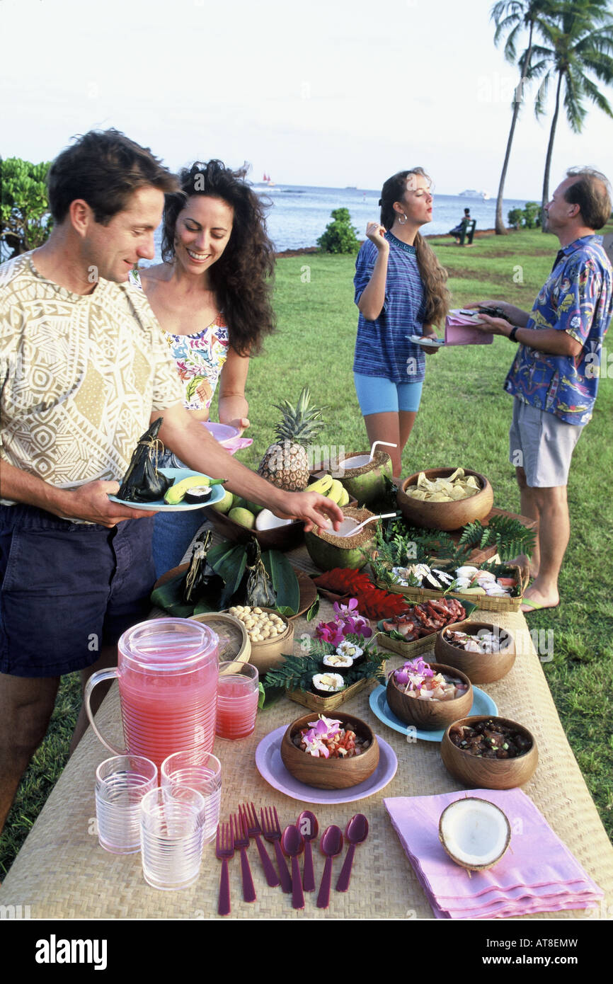 Outdoor-Buffet Luau Picknick mit zwei Paare in der Nähe von Strand, Magic Island, Oahu, Hawaii Stockfoto